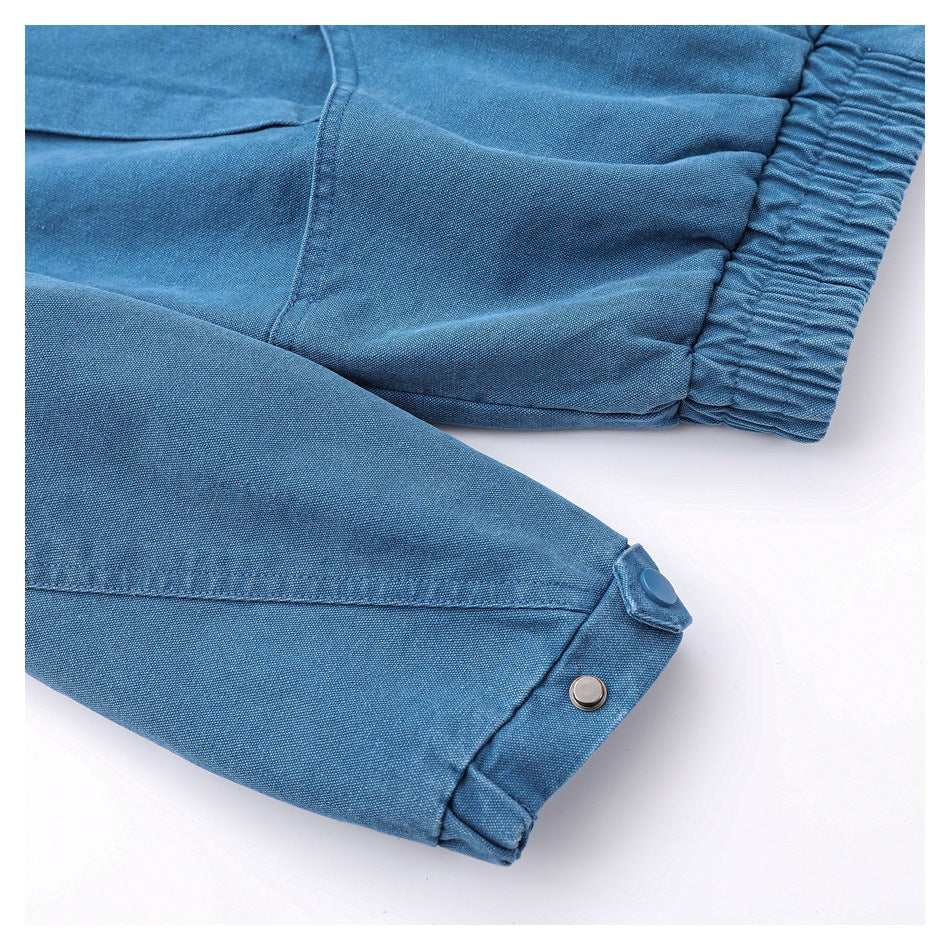 Close-up of a blue garment sleeve with a gathered elastic cuff and a snap-button tab.