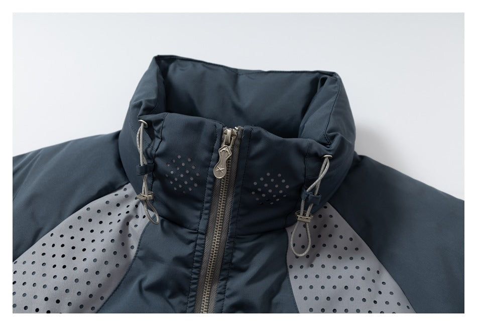 Close-up of a dark slate jacket's high collar, drawcord adjusters, front zipper, and perforated gray panels.