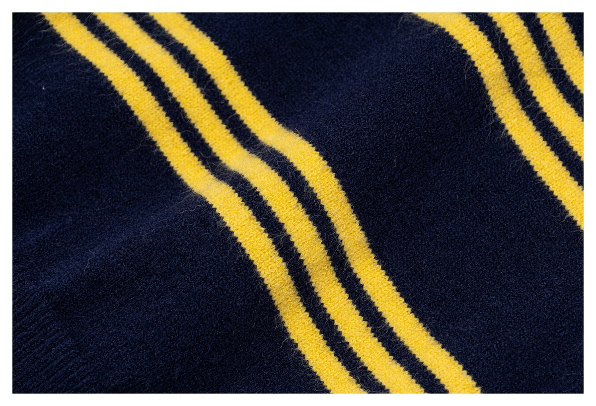 Close-up of navy knit fabric crossed by three mustard-yellow stripes.