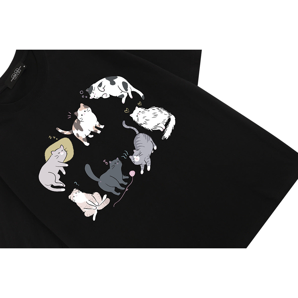 Angled close-up of a black T-shirt with a playful print of illustrated cats.