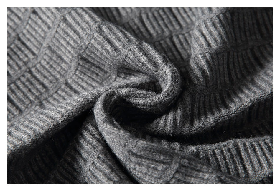 Close-up of the gray sweater's raised geometric knit pattern in soft folds.