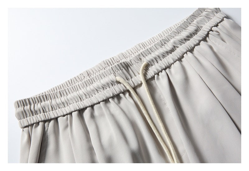 Close-up of the light gray pants' gathered elastic waistband and cream drawstring.