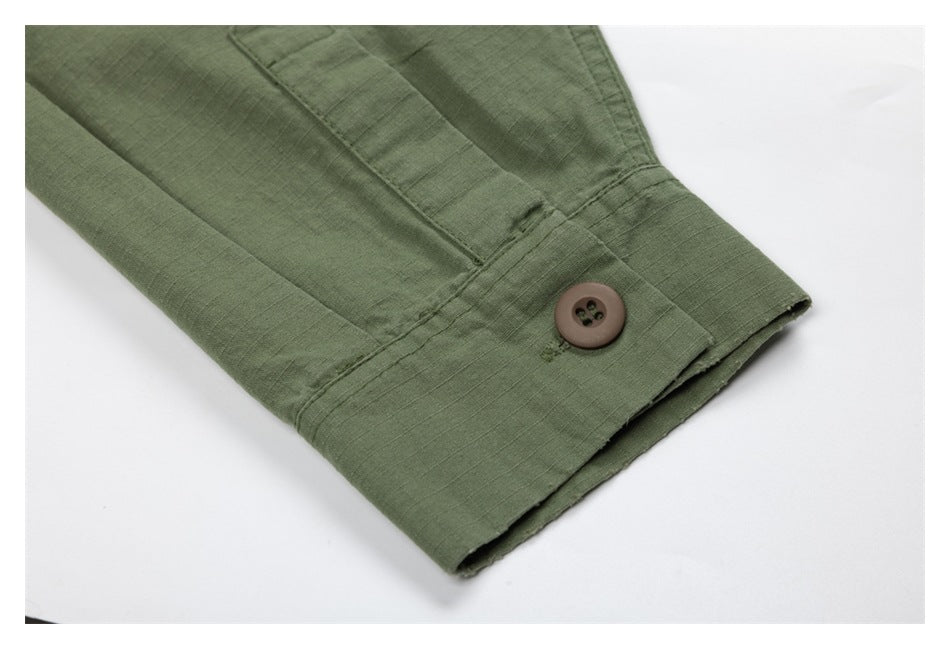 Close-up of an olive-green sleeve cuff with a brown button and stitched placket.