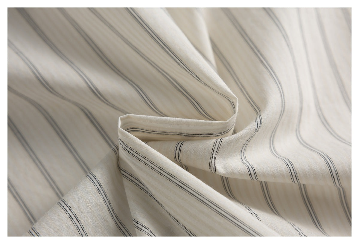 Close-up of draped ivory shirt fabric with fine dark stripes.