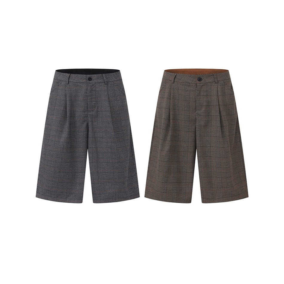 Two pairs of pleated, wide-leg plaid shorts shown from the front in dark gray and brown colorways.