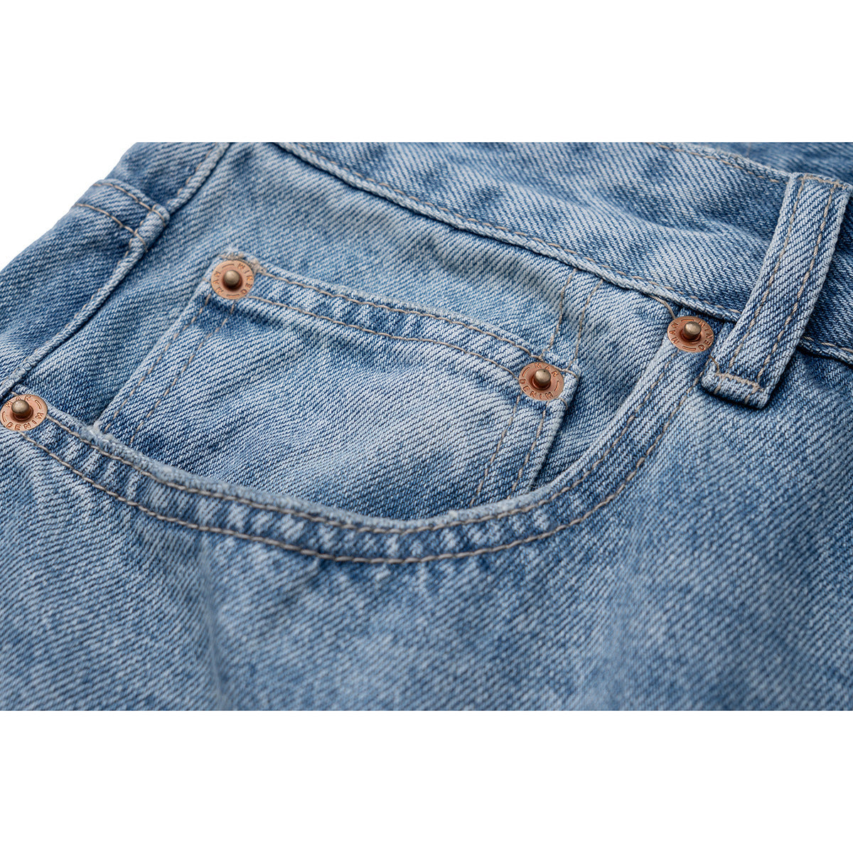 Close-up of a light blue jeans pocket, copper rivets, stitching, and belt loop.
