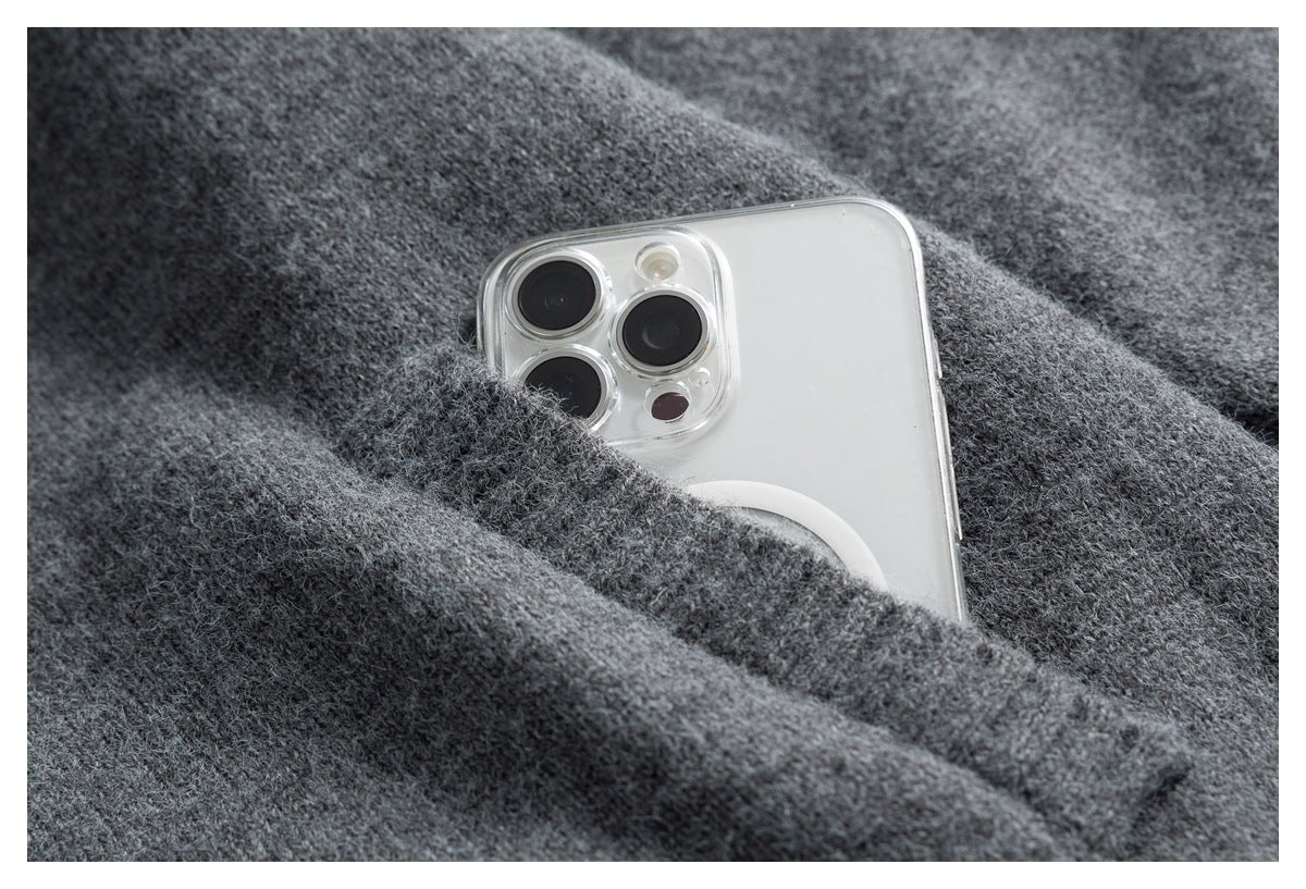 A silver smartphone tucked into a pocket of a charcoal gray fuzzy knit garment.