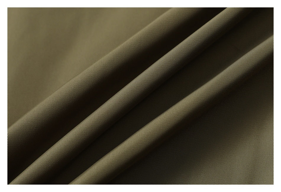Close-up of olive fabric arranged in folds, showing its fine surface texture.