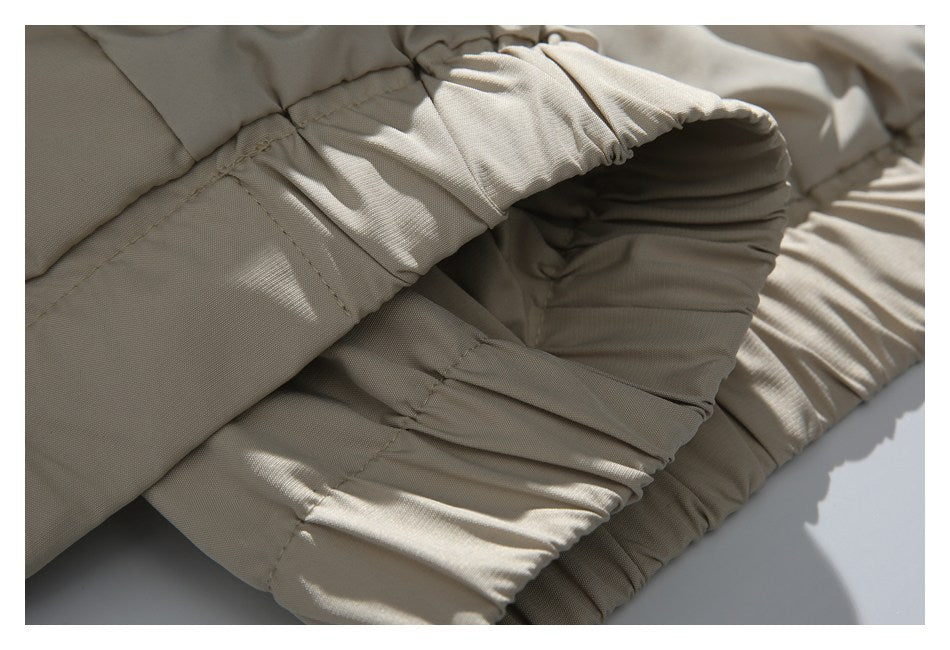 Close-up of the beige jacket’s gathered elastic cuff and stitched seams.