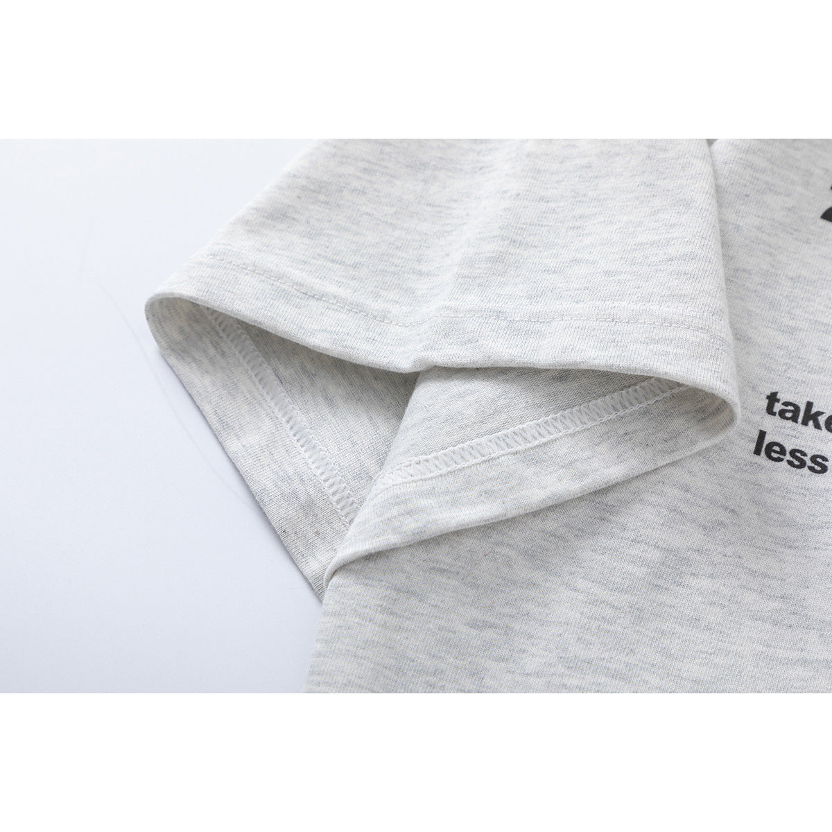 Close-up of the light heather gray T-shirt sleeve opening and stitched hem.