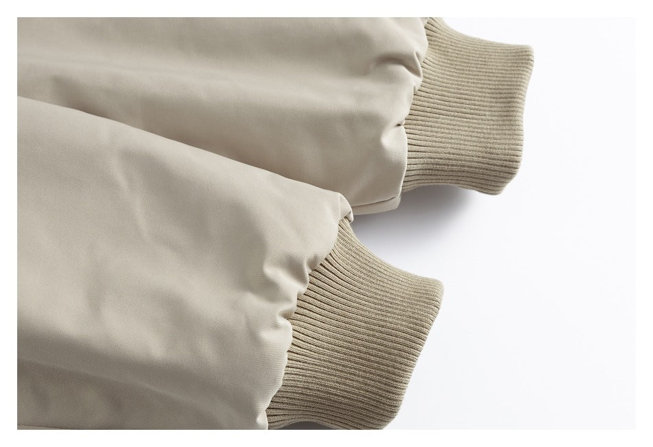 Two beige jacket sleeves ending in ribbed beige cuffs.
