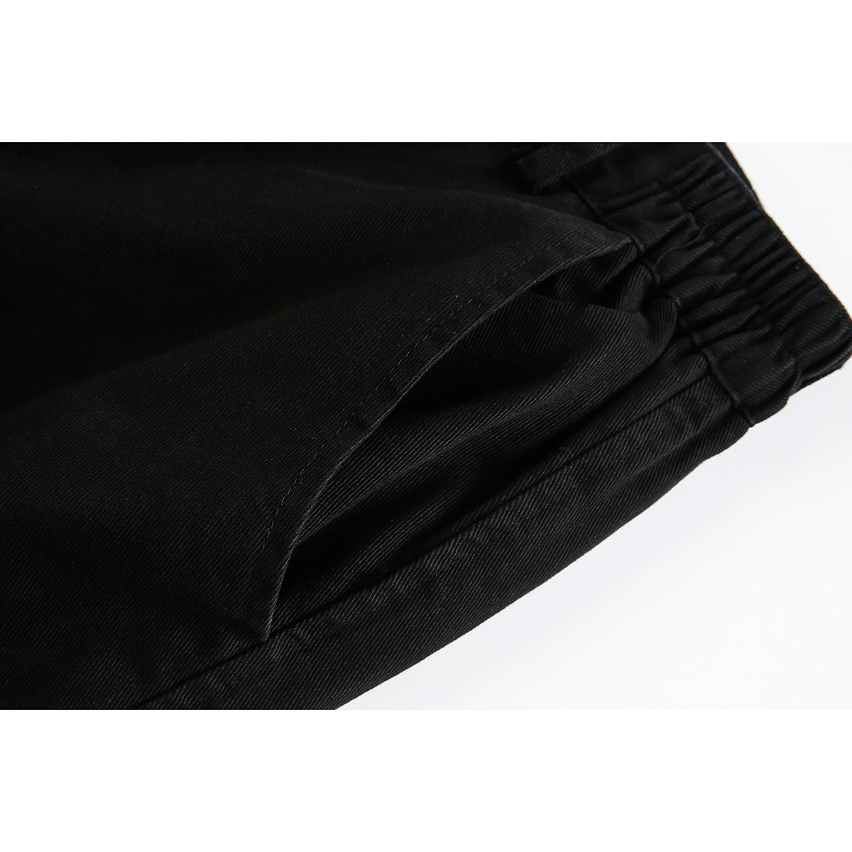 Close-up of the black shorts’ side pocket and gathered elastic waistband.
