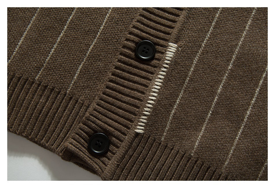 Close-up of a brown striped knit cardigan buttonhole, dark buttons, and ribbed hem.