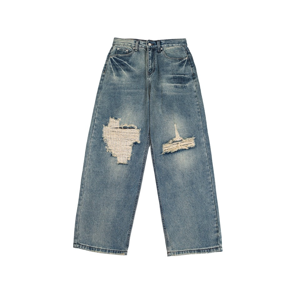 Faded blue wide-leg distressed jeans, front view flat lay, with frayed rips at both knees