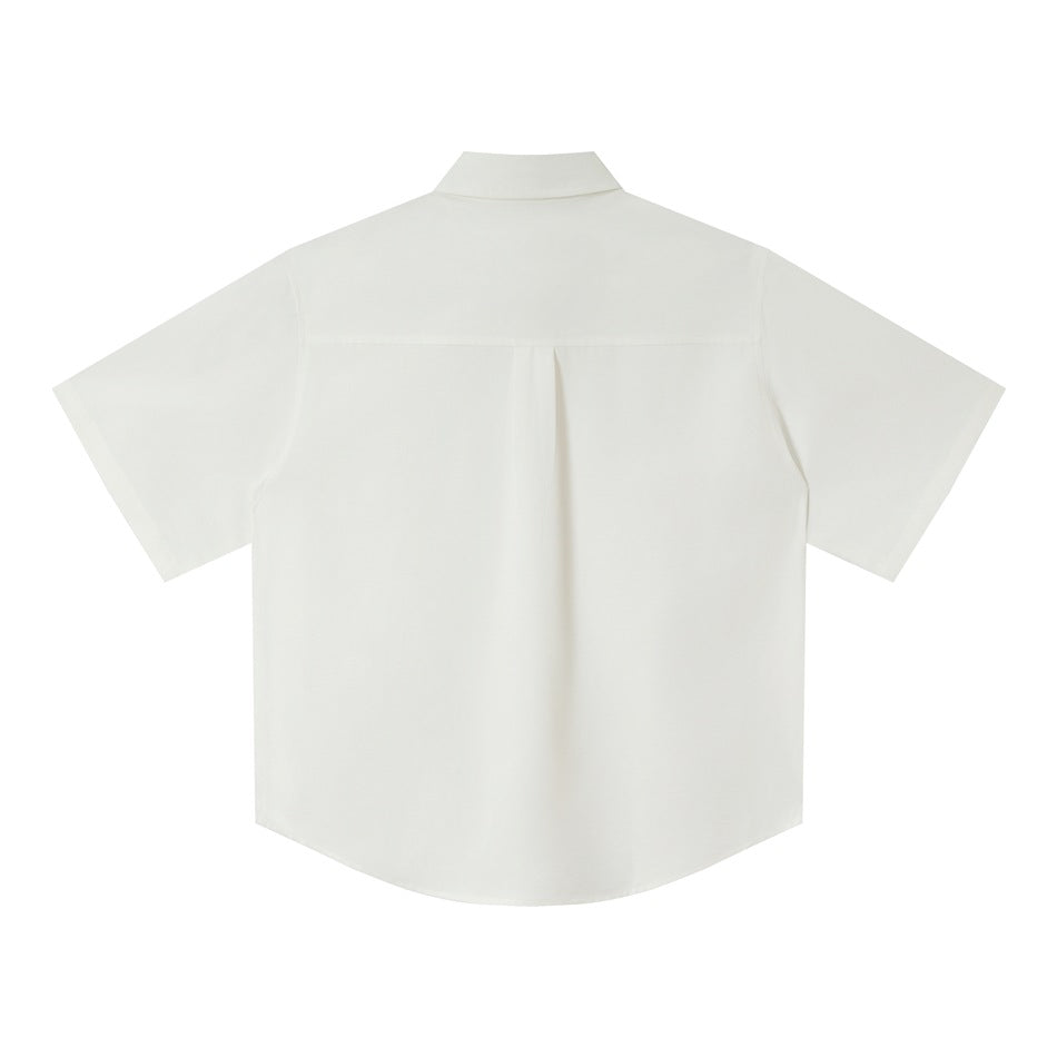 Back view of white short-sleeve shirt flat lay showing yoke seam and center pleat