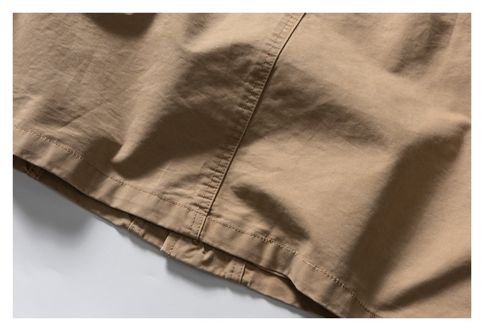 Close-up of a tan garment hem with parallel stitching and a vertical seam.