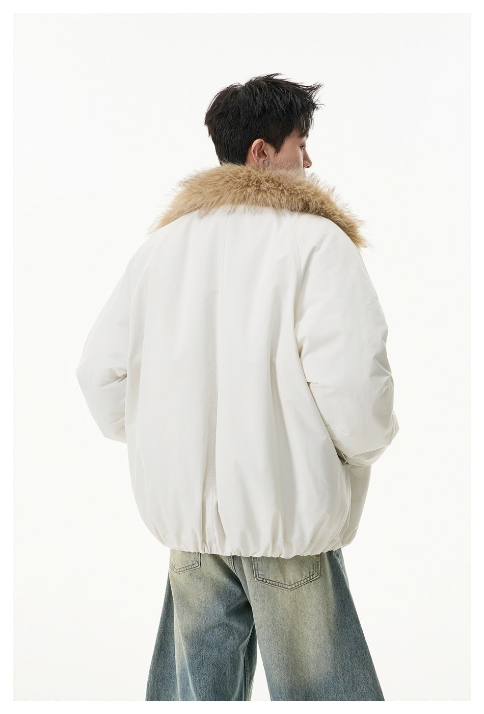 Rear view of a model wearing an ivory jacket with a tan faux-fur collar and gathered hem.