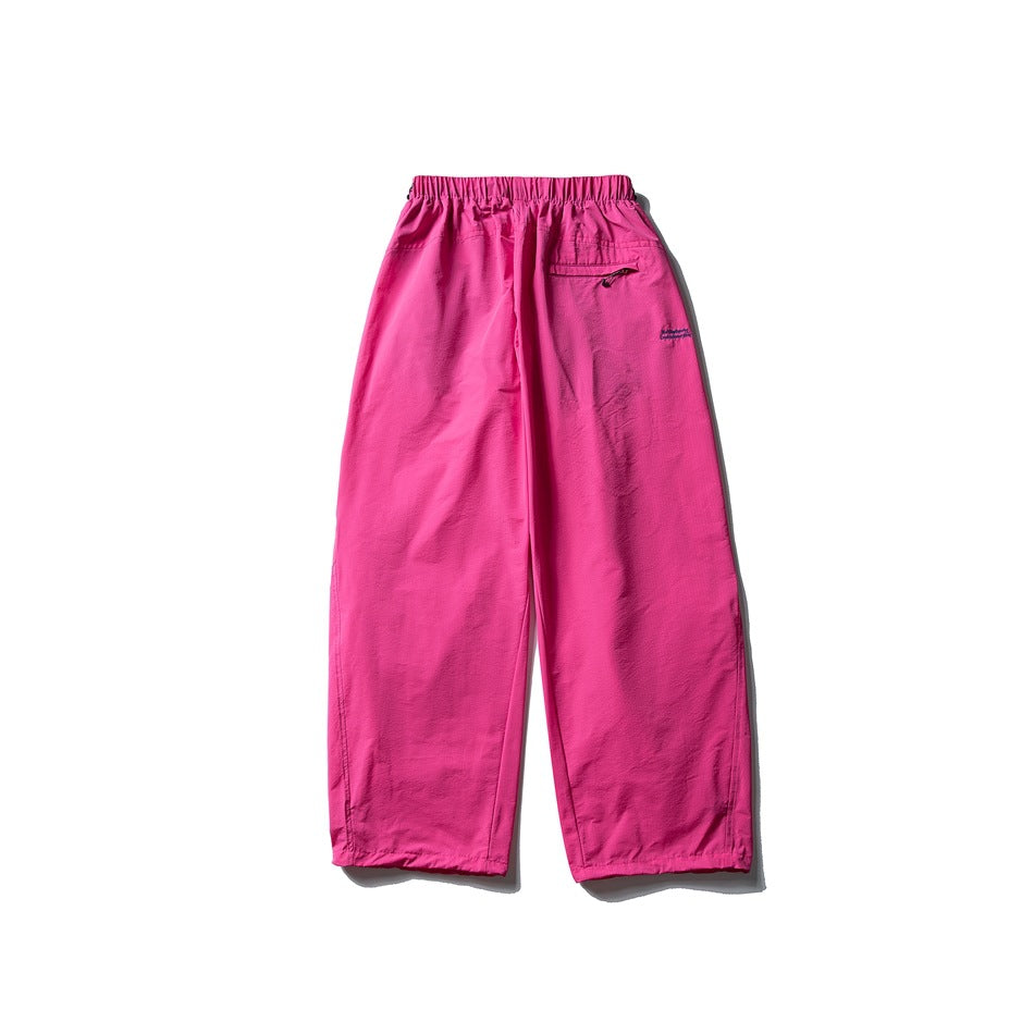 Bright pink wide-leg pants laid flat, with an elastic waist and a small zip pocket at the back.