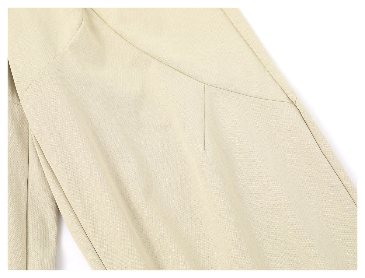 Close-up of the cream trousers' curved panel seams and stitching.