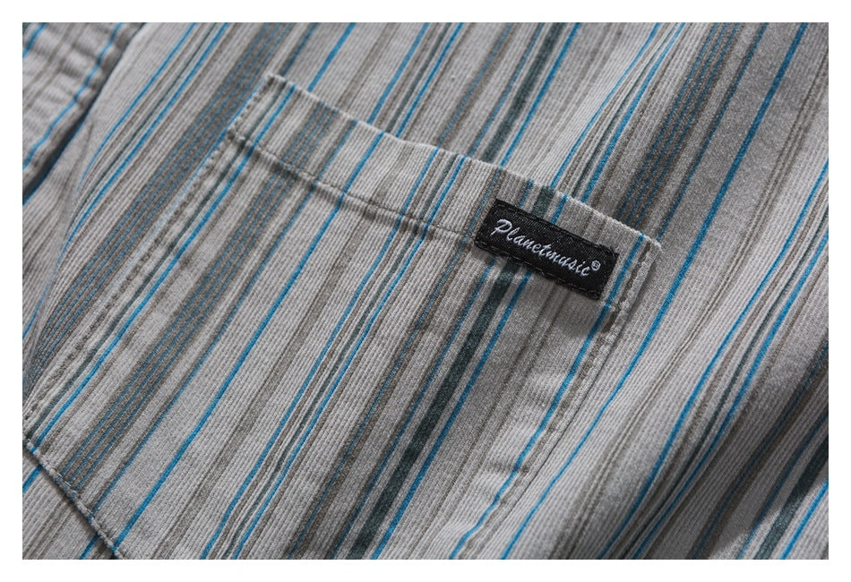 Close-up of gray striped garment fabric with blue and charcoal lines and a small black sewn brand label.