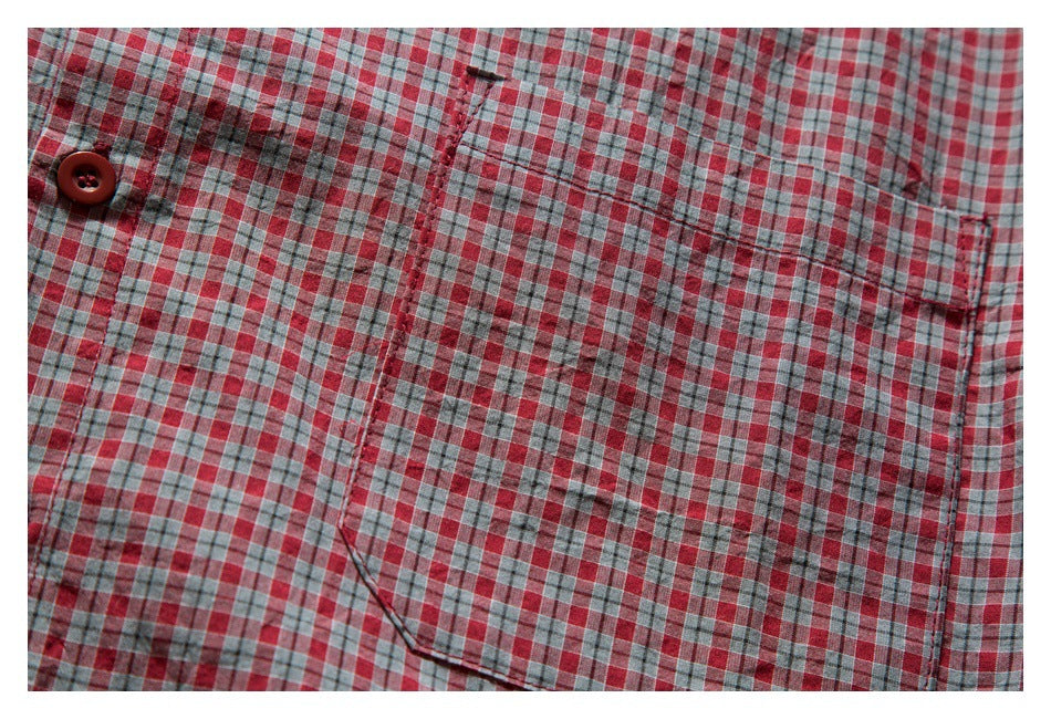 Close-up of the shirt's plaid chest pocket and button placket in red, gray, and white.