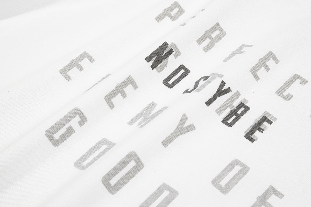 Close-up of scattered gray and black lettering printed on white T-shirt fabric.