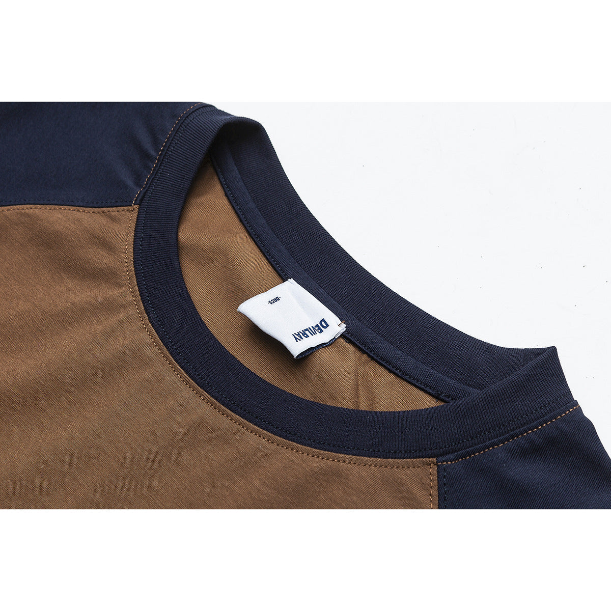 Close-up of a brown and navy color-block shirt neckline with ribbed trim and an interior label.
