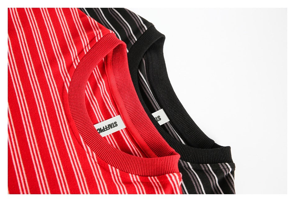 Close-up of red and black striped shirts showing their ribbed crew necks and inner labels.