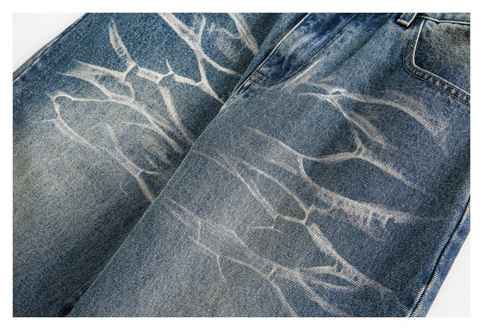 Close-up of the jeans' blue denim legs, showing pale branching fade patterns.