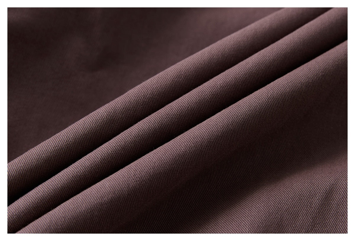 Close-up of dark plum-brown fabric folded to show its fine diagonal weave.