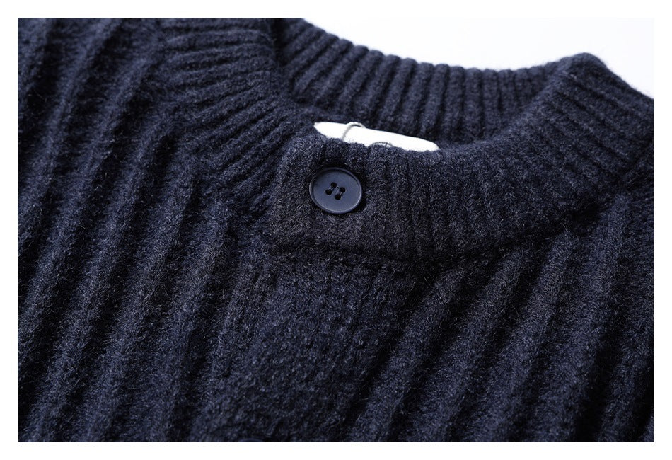 Close-up of the ribbed neckline and top button of a dark navy cardigan.