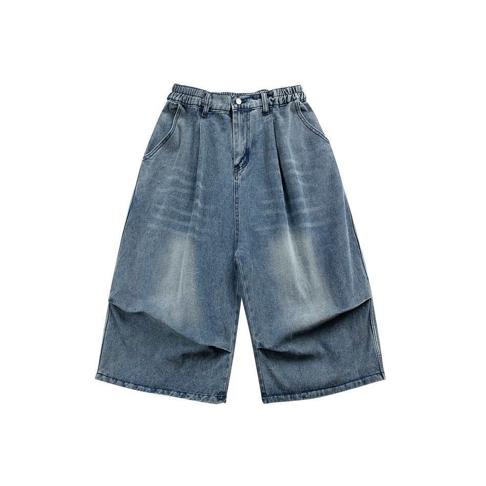 Blue faded denim wide-leg knee-length shorts, front flat lay, with elastic waistband, pleats and slanted pockets