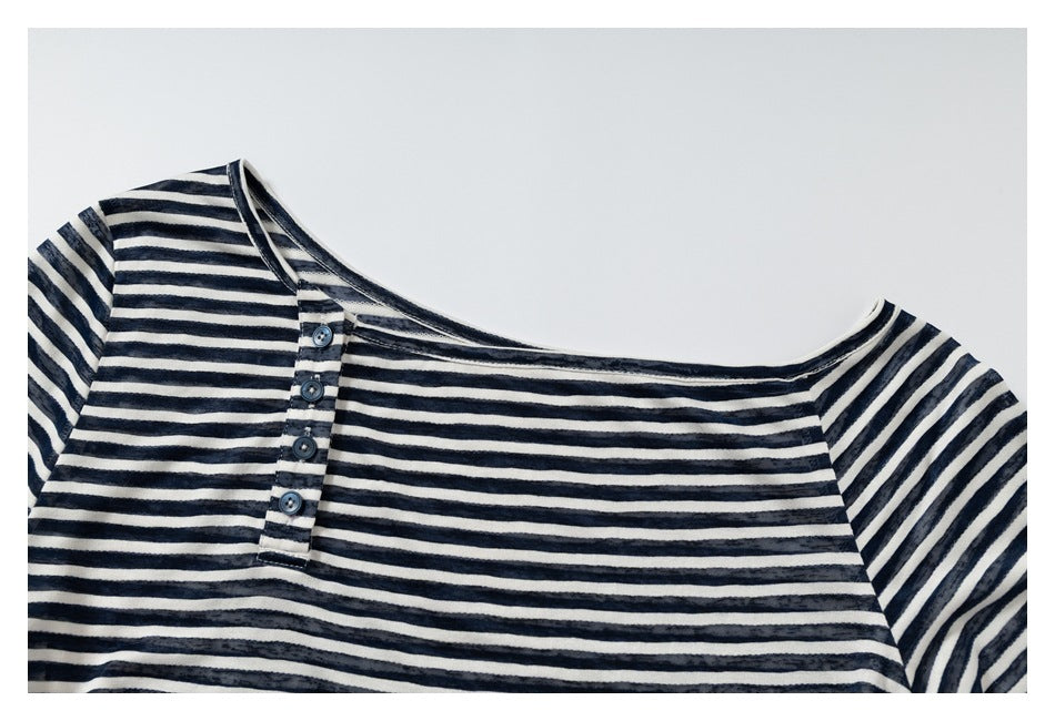 Upper portion of a navy and cream striped top showing the wide neckline, shoulder, and button placket.