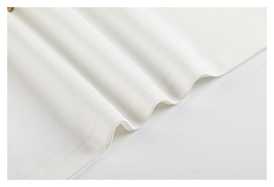 Close-up of the white shirt's hem showing a curved edge and neat double-row stitching.