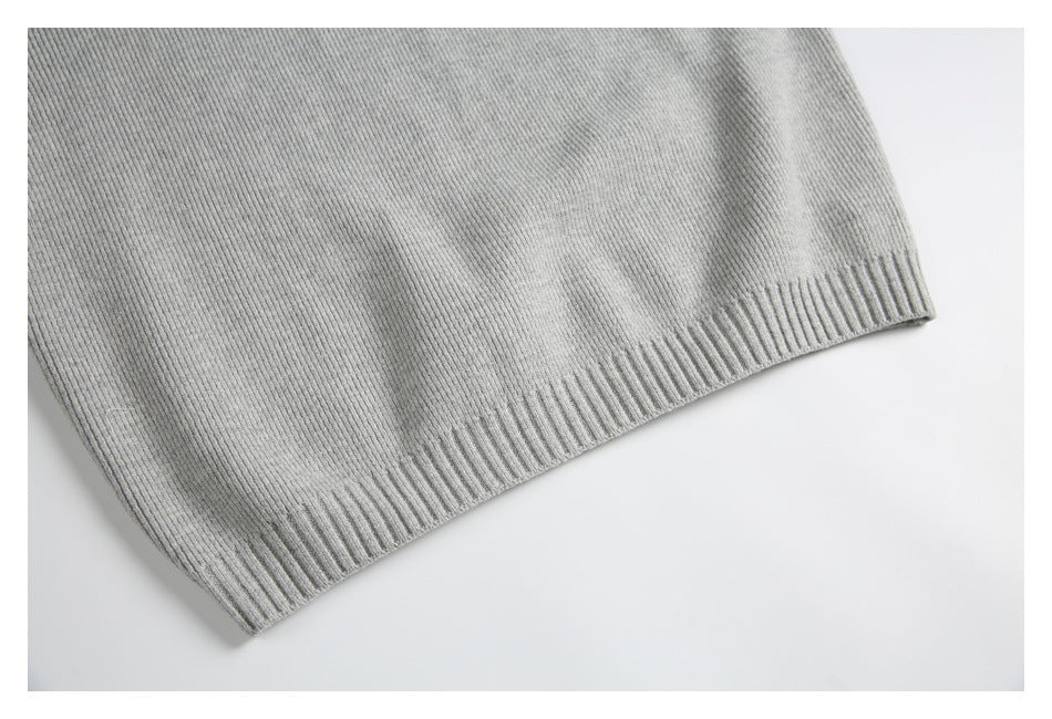 Close-up of the ribbed hem on a light gray knit garment.