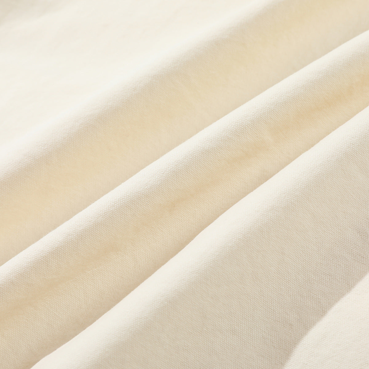 Close-up showing the fine woven texture and folds of ivory fabric.