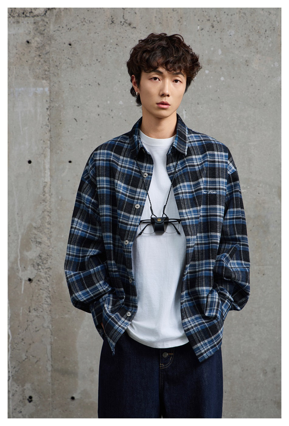 Model wearing an open blue-and-black plaid shirt over a white T-shirt, shown from the front.