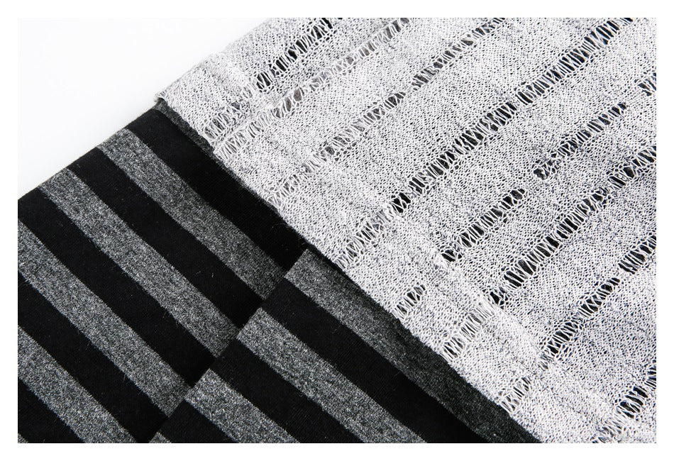 Close-up of light gray open-knit fabric overlapping black and charcoal horizontal stripes.