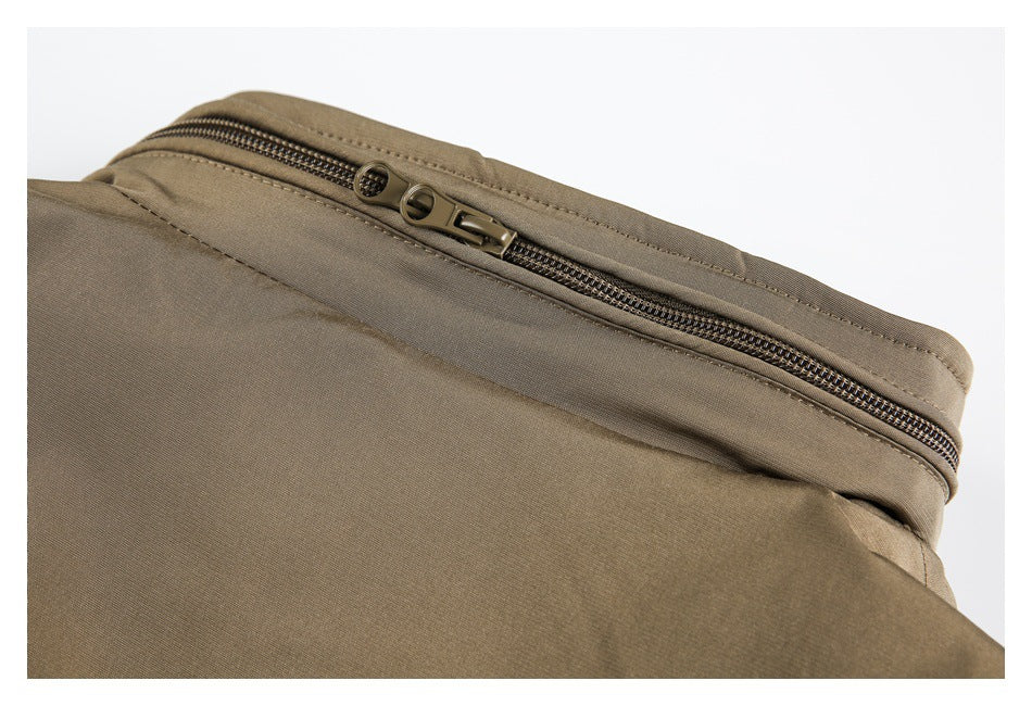 Close-up of a dark double zipper along the edge of a taupe garment.