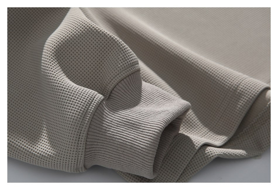 Close-up of a taupe waffle-knit sleeve and ribbed cuff.