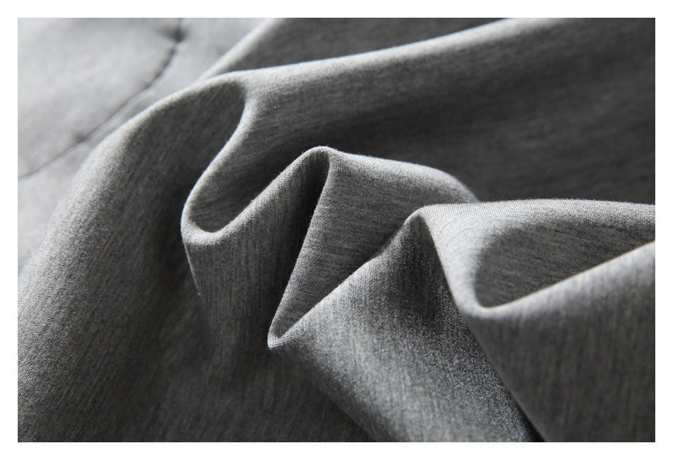 Close-up of softly folded dark gray fabric showing its fine, subtly heathered surface.