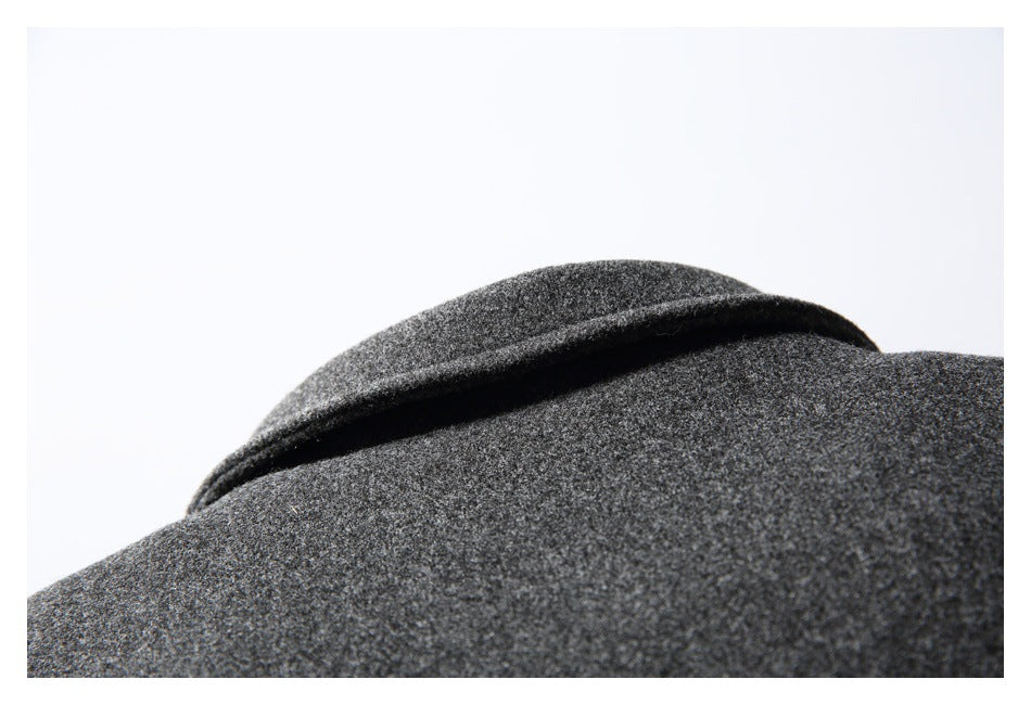 Close-up of a charcoal gray coat's wide folded collar and mottled surface.