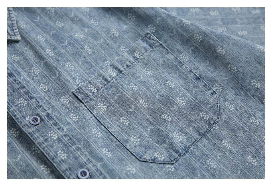 Close-up of a blue patterned button-up shirt showing its chest pocket and buttons.