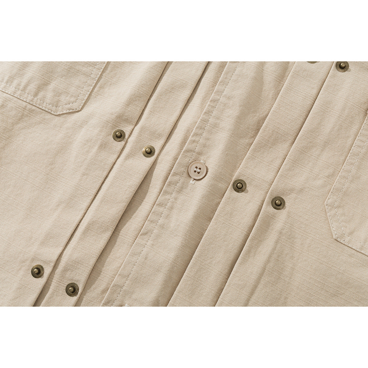 Close-up of a beige shirt's textured fabric, front buttons, and chest pocket edges.