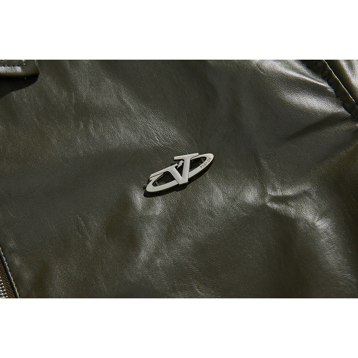 Close-up of a raised silver emblem on the textured olive jacket front.