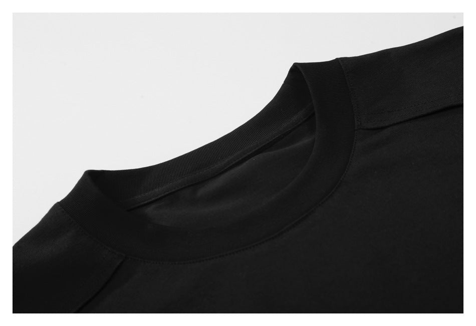 Close-up of the black T-shirt's ribbed crew neckline and shoulder seam.