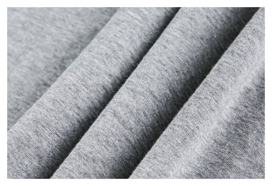 Close-up of gray heather sweatshirt fabric folded into soft ridges, showing its knit texture.