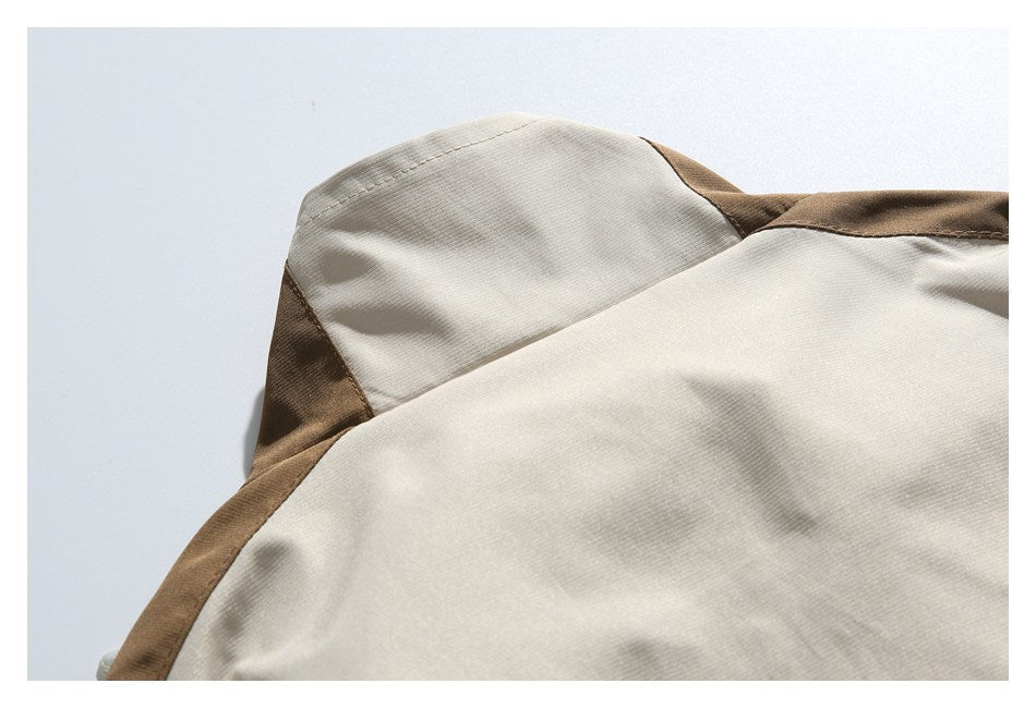 Close-up of a cream garment with brown contrast panels and visible stitching.