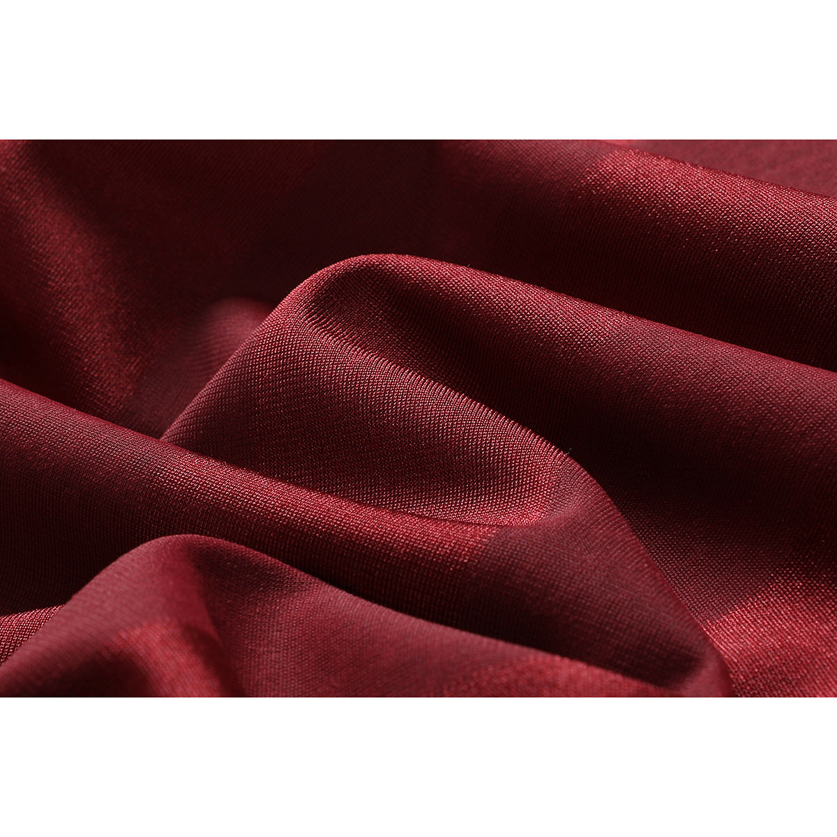 Macro view of red fabric arranged in folds, showing its fine surface texture.