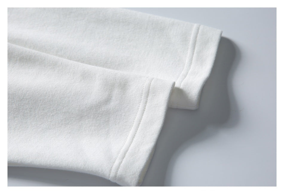Close-up of two white garment sleeve cuffs laid flat, showing the stitched edges.
